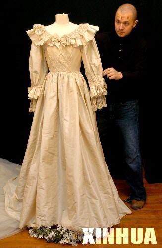 2005年11月29日，在英国伦敦一家拍卖行，一名工作人员展示即将被拍卖的戴安娜王妃的婚纱复制品。在1981年7月29日查尔斯王子与戴安娜王妃的盛大婚礼上，戴妃曾穿着一件裙摆达8米长的象牙色拖地长裙,惊艳四座。这次将被拍卖的复制品是由原设计者依原样复制,预计拍卖价将超过5万镑。