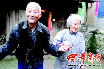 看见记者照相，107岁的李喜财拉起92岁老伴的手，也浪漫一回