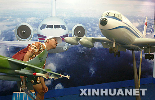 7月5日，观众在中国一航第一飞机设计研究院设计的飞机模型前参观。 当日，“2007上海国际航空航天技术与设备展览会”在上海展览中心开幕，130余家中外企业的航空航天高新技术产品展出。     新华社发（郑悦摄）