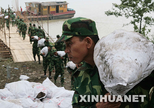  7月15日，揚州江都民兵突擊隊搬運沙袋。為迎戰即將到來的淮河第三次洪峰，位於淮河入江水道行洪處的揚州市江都邵伯湖崇灣凹段全面進入臨戰狀態。 新華社發(王卓 攝) 