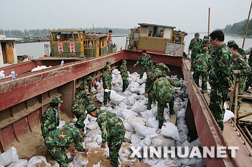 7月15日，揚州江都民兵突擊隊搬運沙袋。為迎戰即將到來的淮河第三次洪峰，位於淮河入江水道行洪處的揚州市江都邵伯湖崇灣凹段全面進入臨戰狀態。 新華社發(王卓 攝) 