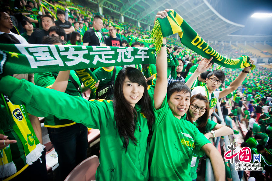 北京国安队主场球迷在中场休息时高举手上的毛巾为国安队加油