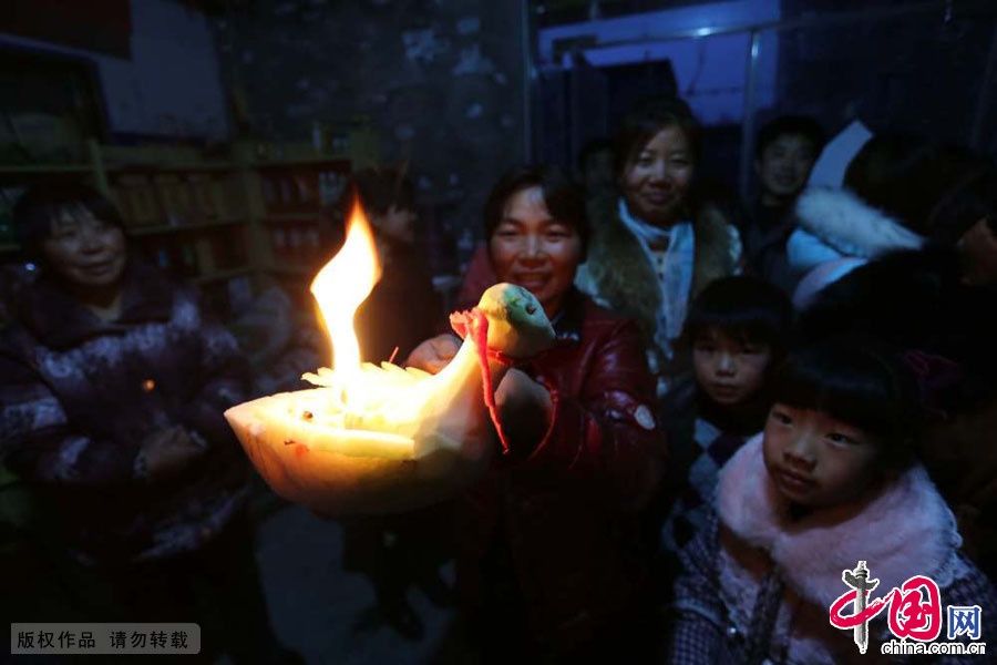 3月9日，河南原阳县陈杏兰村农民正在展示她雕刻的鸭子形状的“创意”萝卜灯