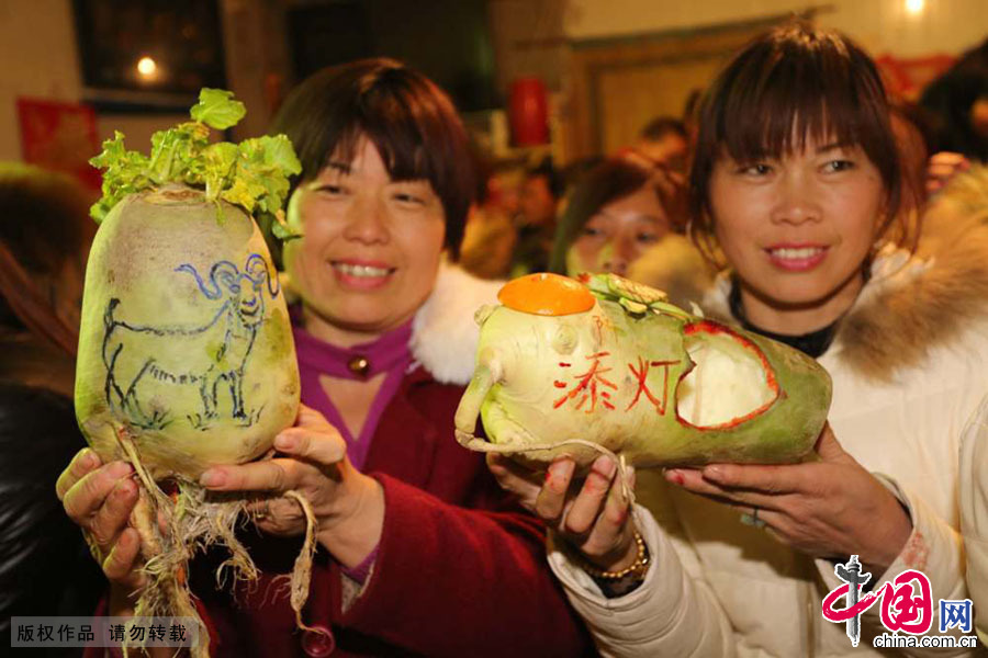 3月9日，河南原阳县陈杏兰村的村民展示他们雕刻的“创意”萝卜灯。
