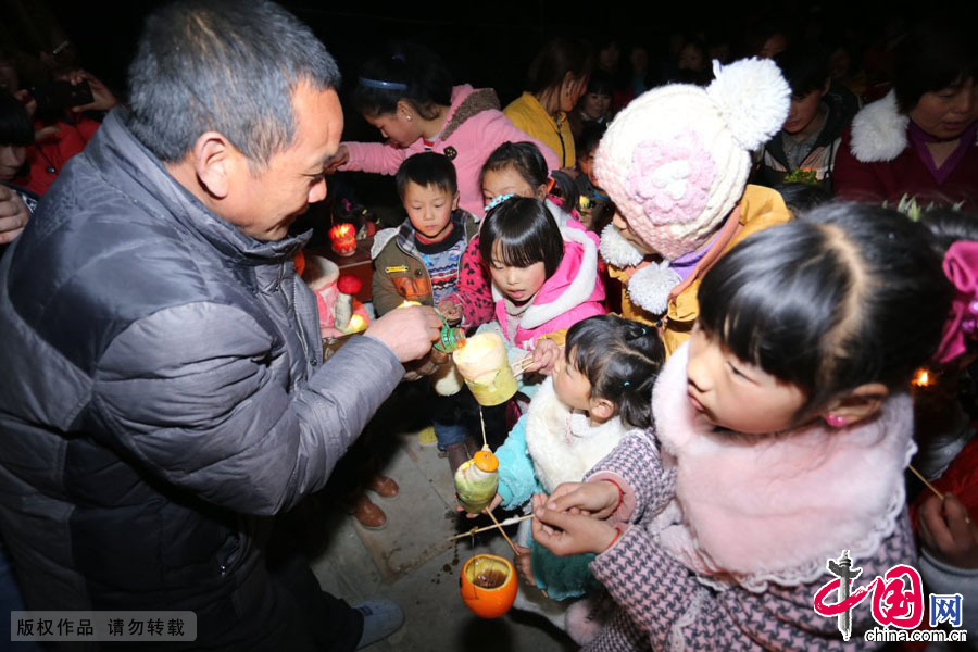 3月9日，河南原阳县陈杏兰村，一位村民为孩子们的灯盏添上食用油。