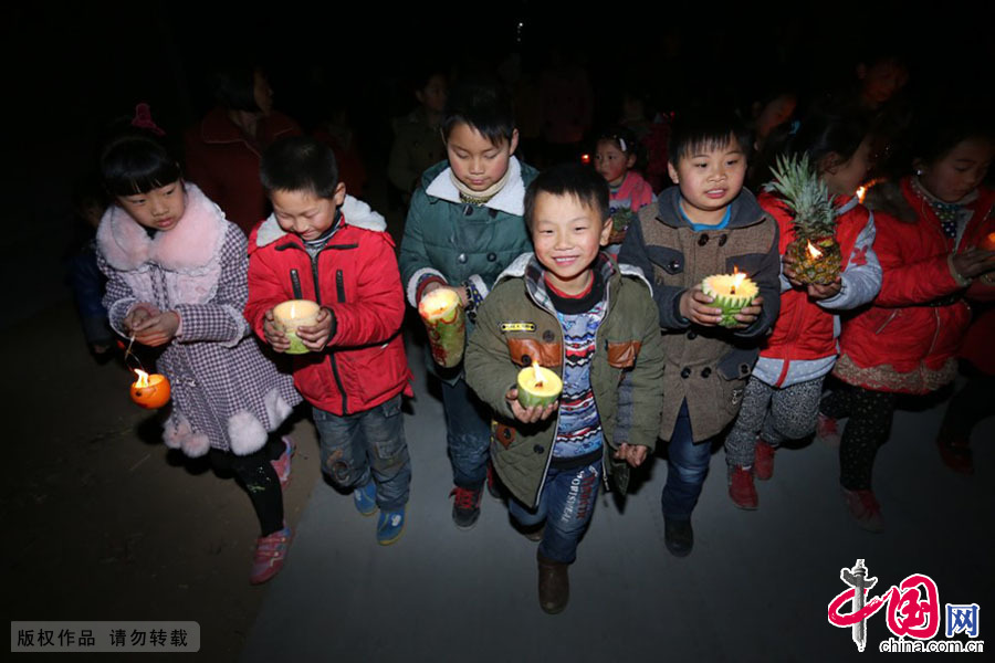 3月9日，河南原阳县陈杏兰村的孩子们挑着、捧着萝卜灯走街串巷玩花灯。