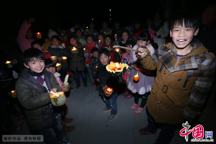 月9日，河南原阳县陈杏兰村的孩子们挑着萝卜灯走街串巷，一小孩兴高采烈地展示他的花灯。