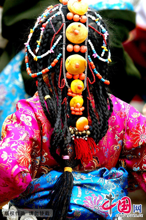 女子带一种华贵的头饰，藏族叫做“巴珠”。具有代表性的，那是一个形似 “人”字的饰物，将分叉的一方朝前固定在头顶，当中是珠璎顶髻，披散在身后的一股股小辫，缀满金银、珠玉、珊瑚、宝石。这在古代，是只有贵族才能够配戴的头饰。