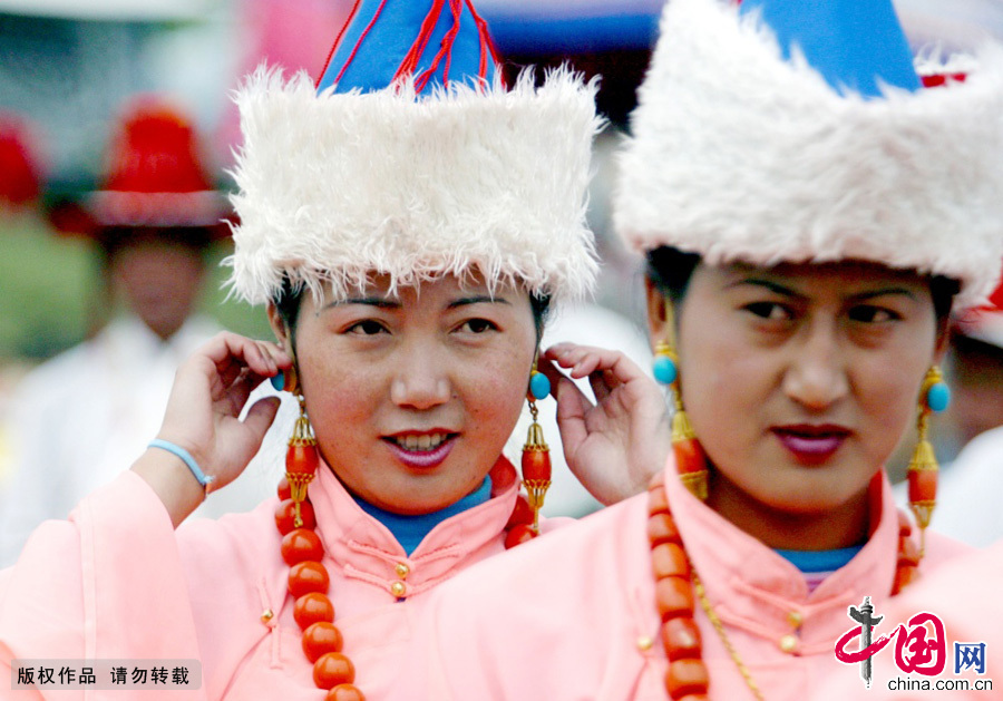  藏族妇女戴的帽子叫“町玛”，是棕蓝色彩线氆氇制做的圆筒帽，帽的底边截一段为留辫子处，妇女的耳坠以珊瑚及珍珠连串而成，长约15厘米。