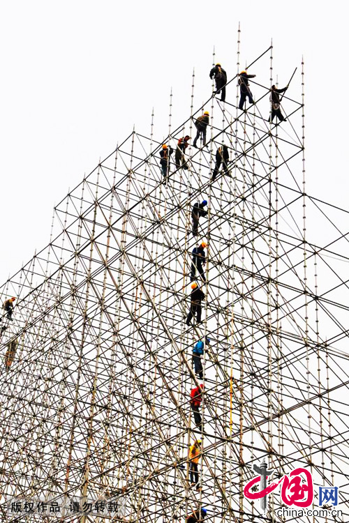 2012年11月30日，北京天坛，建筑工地上的工人在高达15米架子上作业。这是一个极其危险的工作，他们的一不留神，便会粉身碎骨。中国网图片库 郑永摄