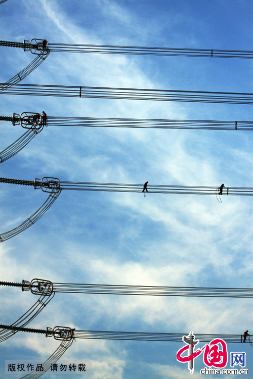   2013年7月15日凌晨5点30分，30位电力工人分成两组在浙江嘉善境内境内皖电东送特高压工程的7座高压铁塔上进行“走线”验收工作。