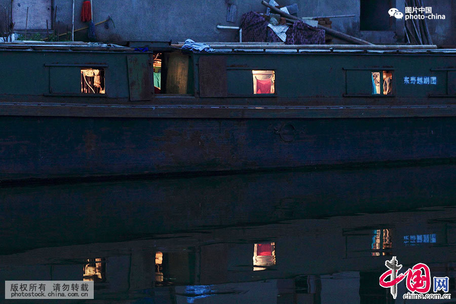     2015年5月16日傍晚，浙江绍兴市镜湖新区灵芝镇张市村河埠头，一个普通戏班子蜗居在一艘旧轮船上。客船不大的空间被分割成许多个单间，大小只有3平米左右，拉上布帘就算是一间独立的”房间“了。中国网图片库 李瑞昌/摄 