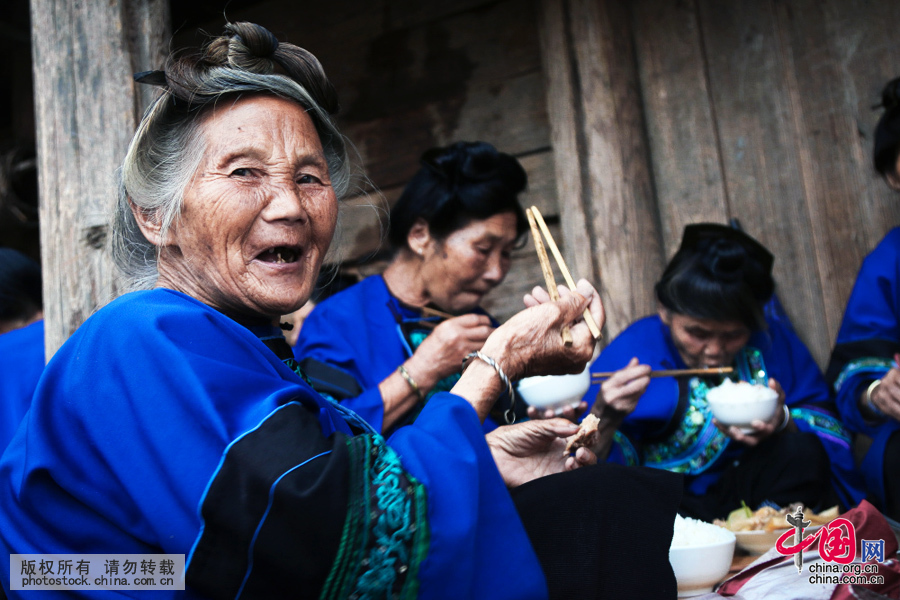 侗族纯朴的老人们，在鼓楼里品着“炕鱼”和“烧鱼”的侗家风味佳肴，拉着家常。中国网图片库 张晖摄