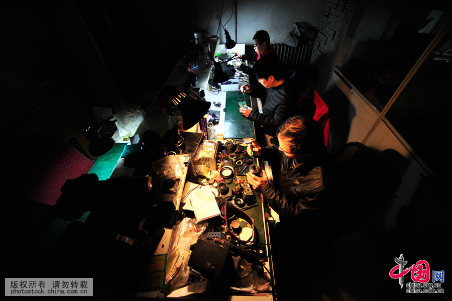  深夜，詹春明師傅與他的同事們在他的“相機醫院”內緊張地忙碌著，對一部有著“疑難雜症”的相機進行集中“會診”。“挑燈夜戰”是經常的事兒。