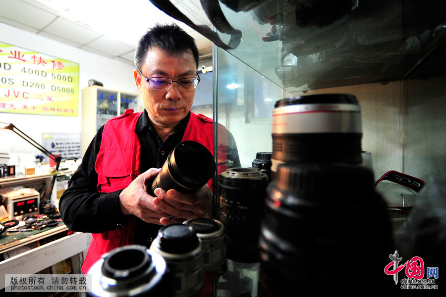 对每一只排除故障的相机镜头，詹春明师傅都对其进行查验登记。中国网图片库 王伟摄