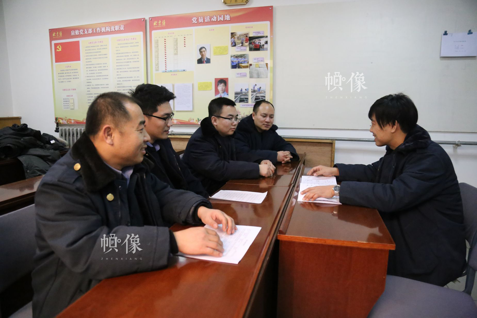 工长马鑫（右）与部门同事沟通交流近期工作情况。中国网 黄富友/摄