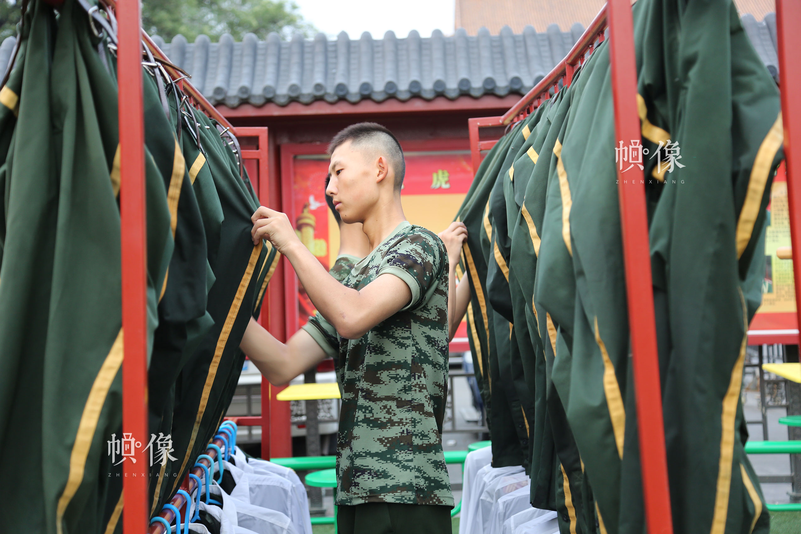 每一次升旗結束，國旗護衛隊隊員的禮服都浸滿了汗水，圖為國旗護衛隊員整理軍裝。中國網記者 黃富友 攝