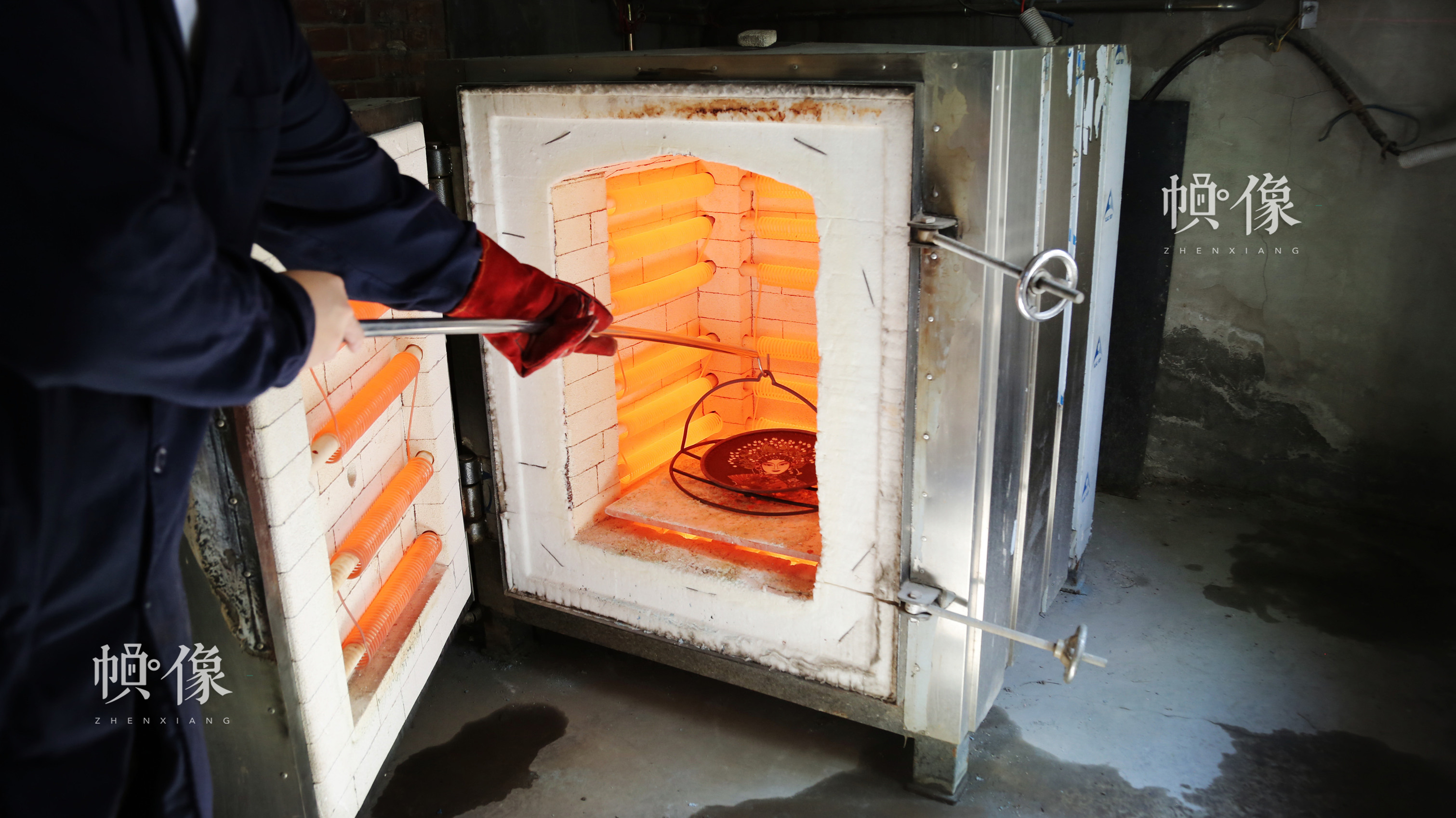 工匠把待燒的銅胚放到高溫達800多度的電火爐中燒制。中國網記者 趙超 攝