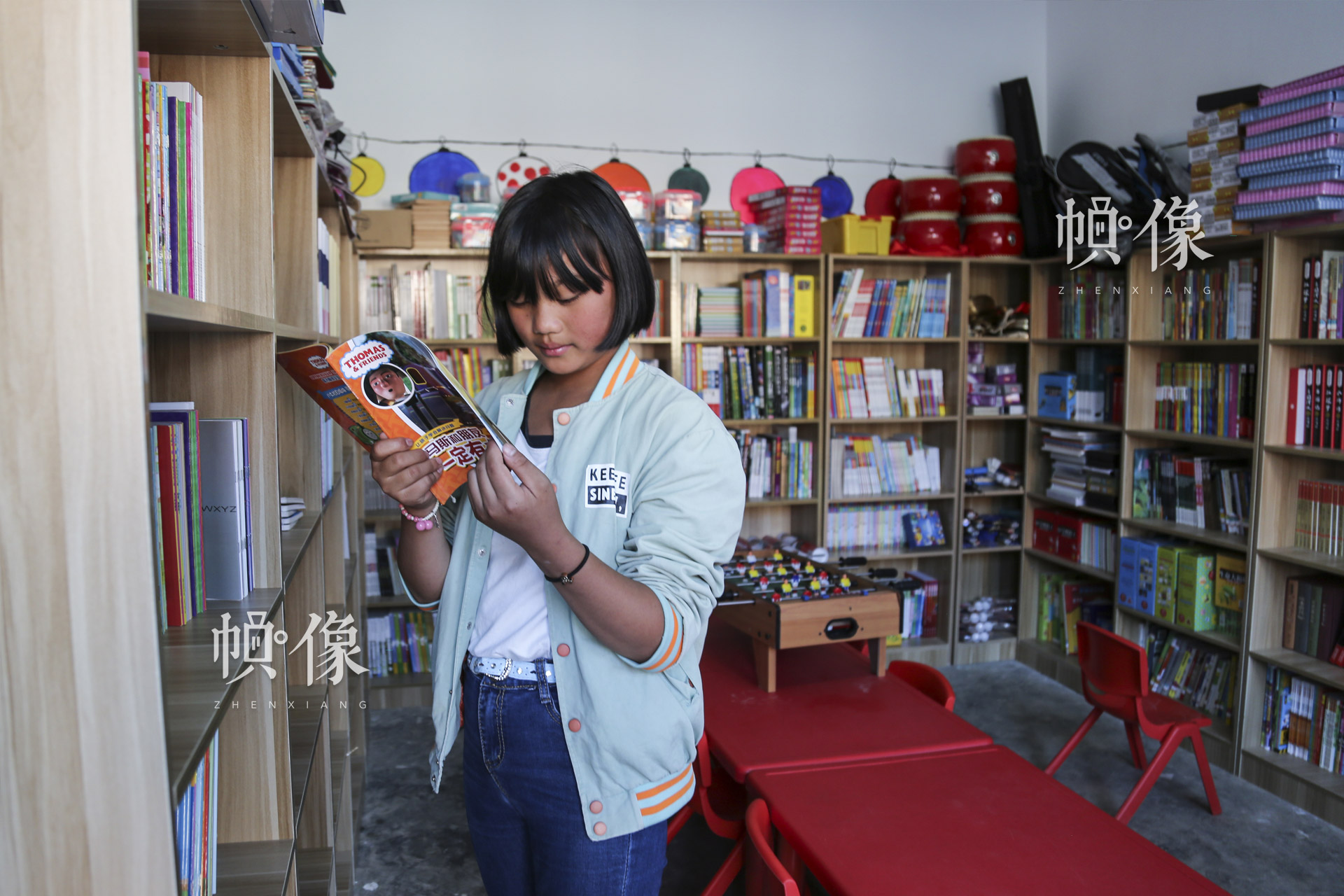 肖歡歡喜歡看勵志書籍和科學雜誌。週末放假，在安馬村“兒童快樂家園”的閱讀室裏經常能看到肖歡歡。中國網記者 黃富友 攝