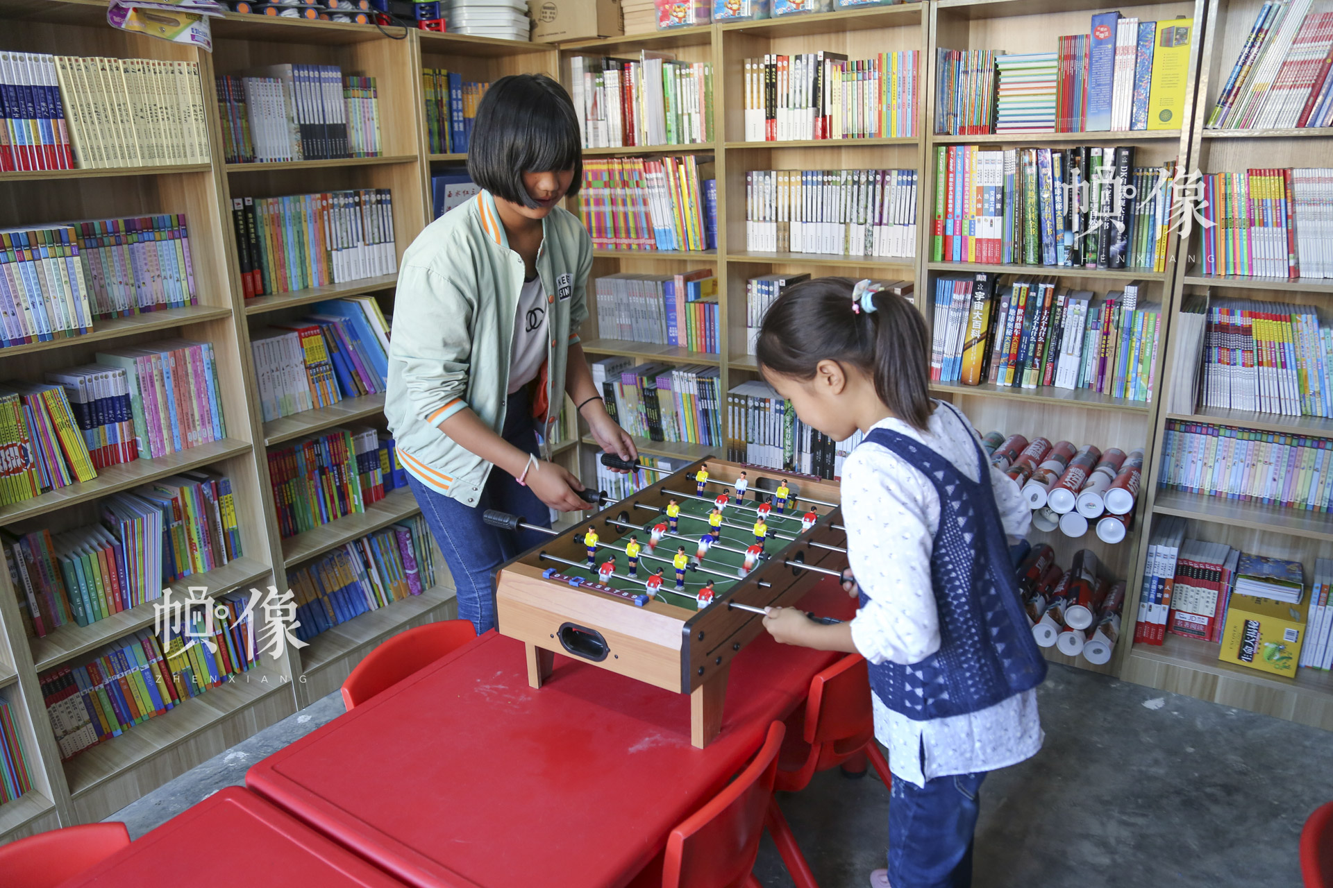 肖歡歡和金子涵在兒童快樂家園玩桌遊。“這裡有很多的圖書，還有很多的玩具，每天都有很多的小朋友來這裡玩，我就感到非常的開心、歡樂。”肖歡歡説。中國網記者 黃富友 攝