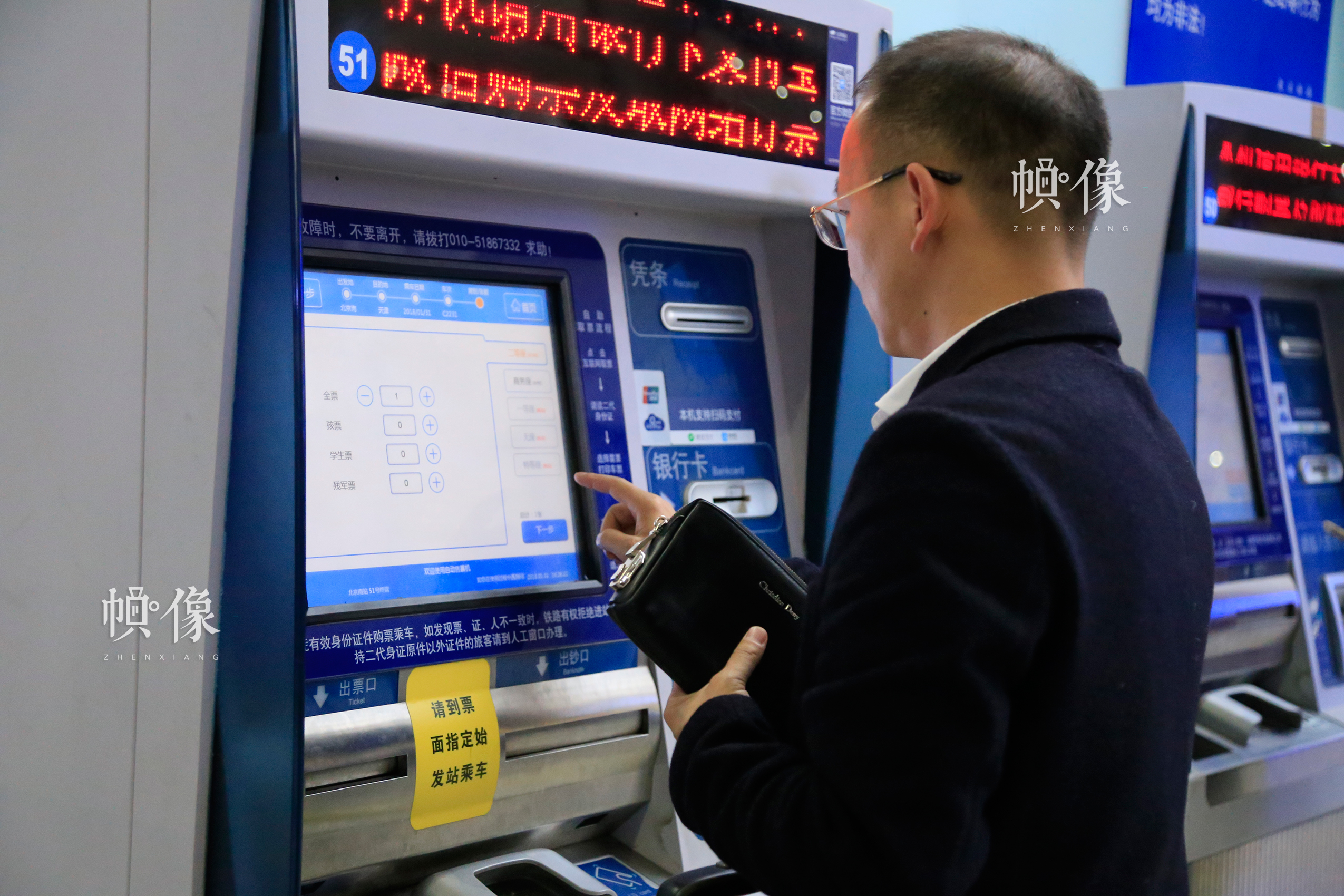 北京南站自助售取票机前，一位乘客购买车票。中国网实习记者 韩依 摄