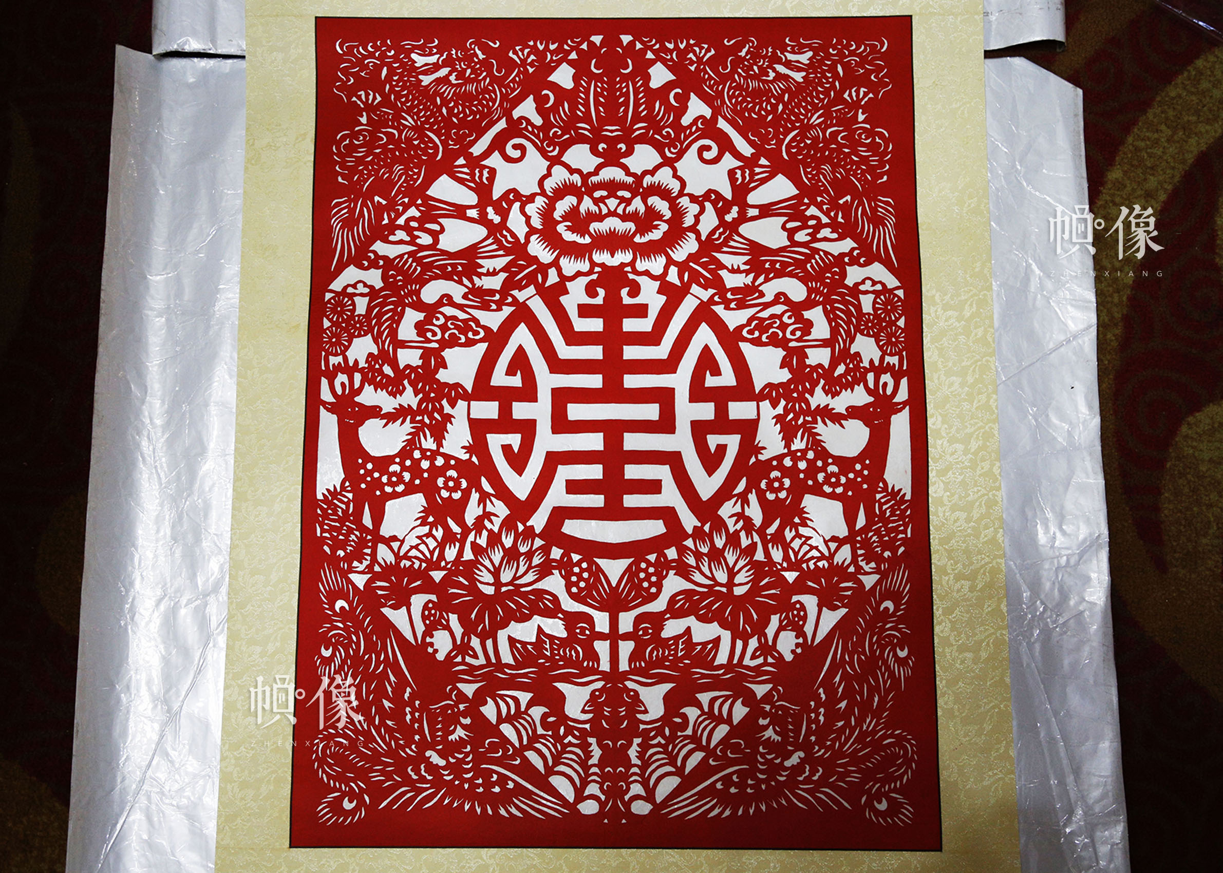 姚雨林的剪纸作品，其中包含了“福”“禄”“喜”“鸳鸯”等多种在中国传统文化中代表喜庆吉祥的元素。中国网实习记者 张钰 摄