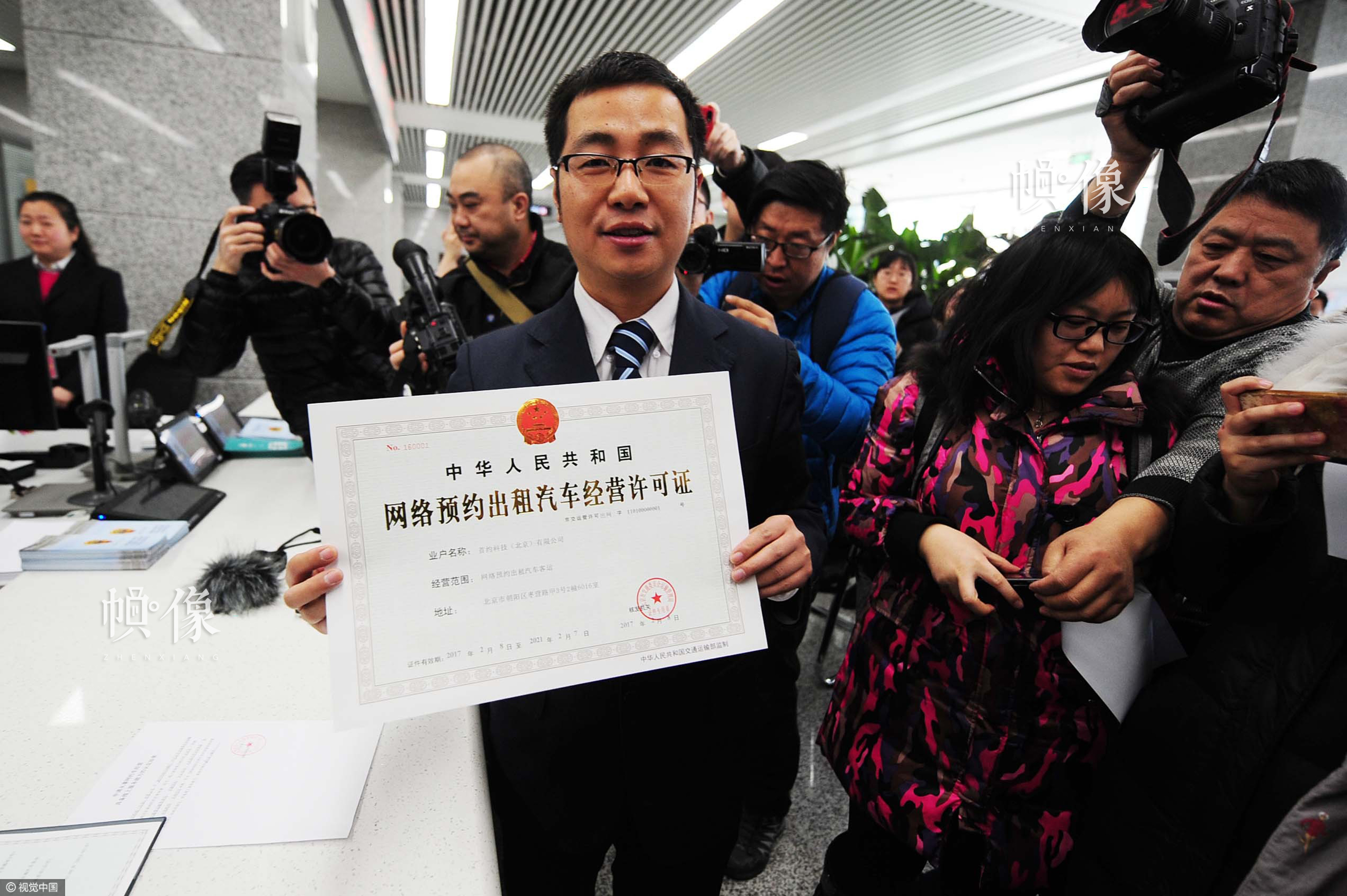 2017年2月8日，北京，首汽约车负责人第一时间来到北京市政务服务中心，工作人员向首汽约车颁发北京网约车平台经营许可证。这是北京发放的首家省一级平台资格许可证。图片作者:北京青年报 袁艺/视觉中国