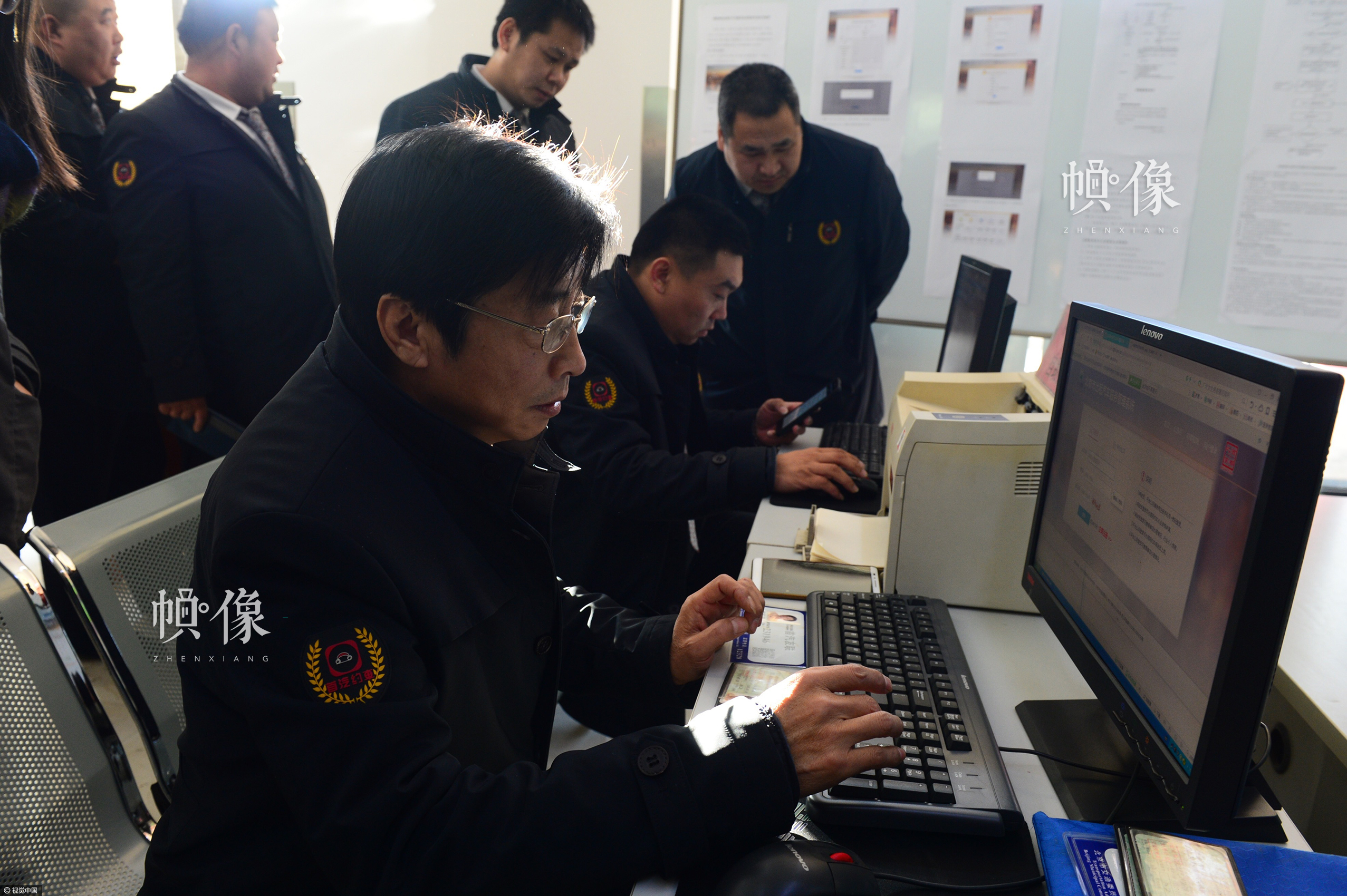2016年12月22日，北京网约车新政颁布的第二天，几名司机正在申请网约车驾驶员考试。黄亮/视觉中国