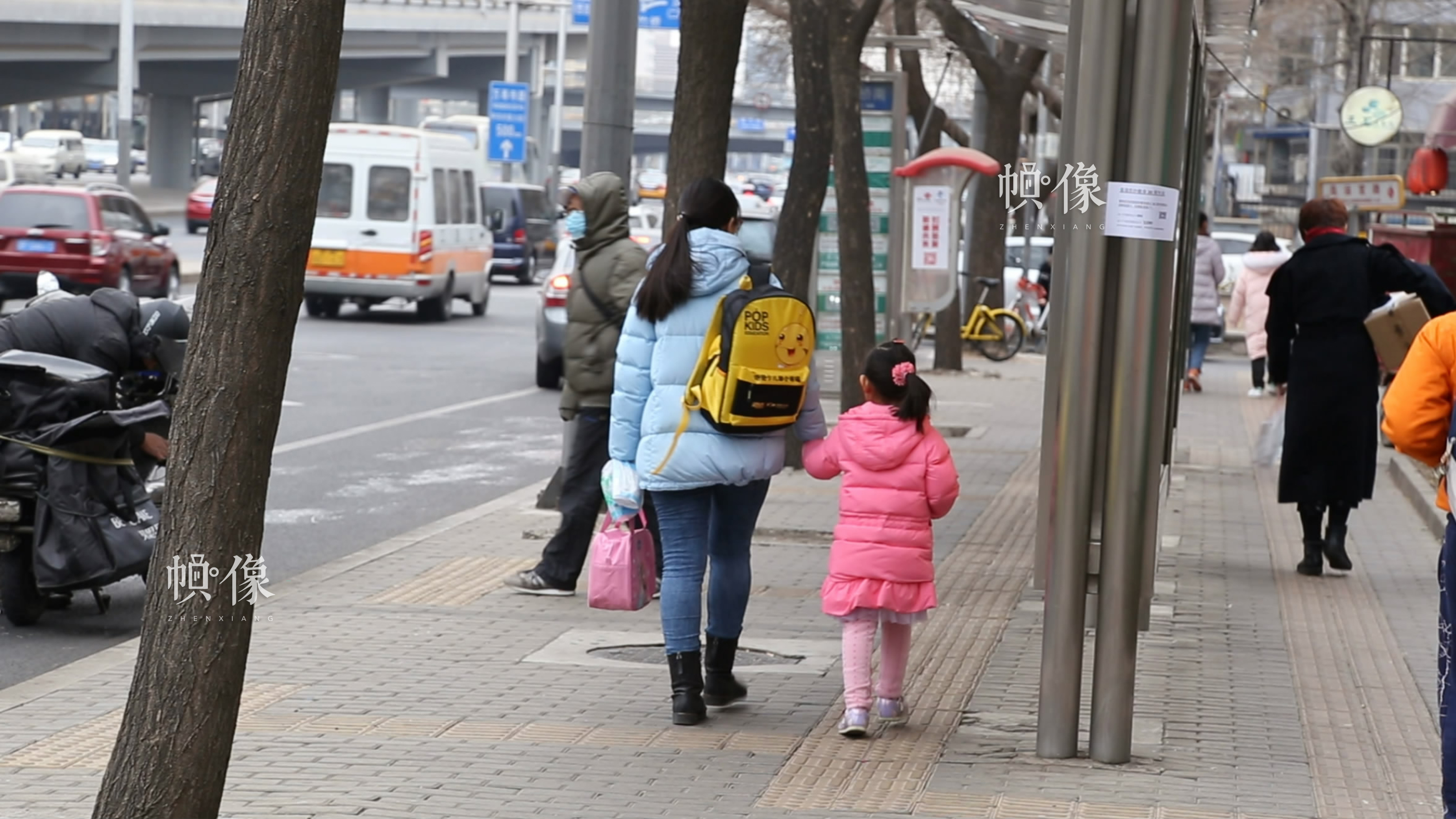 2018年3月6日下午，北京海淀实验小学附近，一女子牵着刚下学的女儿走在回家的路上。中国网记者 赵超 摄