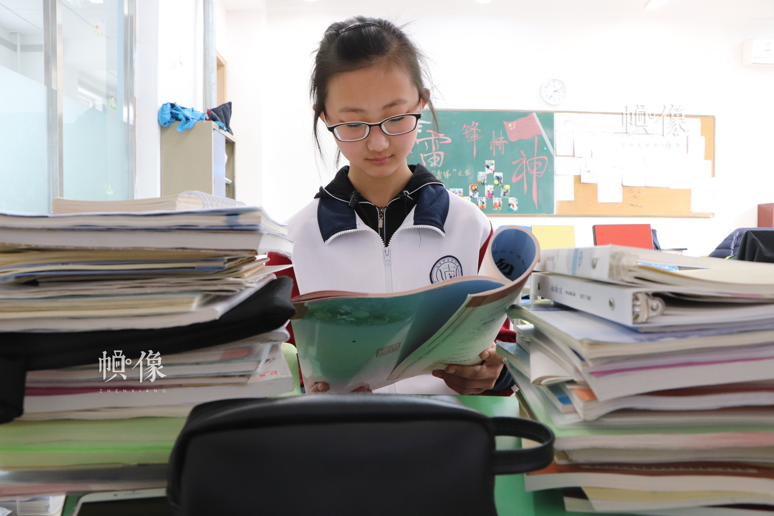 北京市石景山区某中学，午休时间一学生专注读书，桌上堆满学习用书。中国网实习记者 韩依 摄