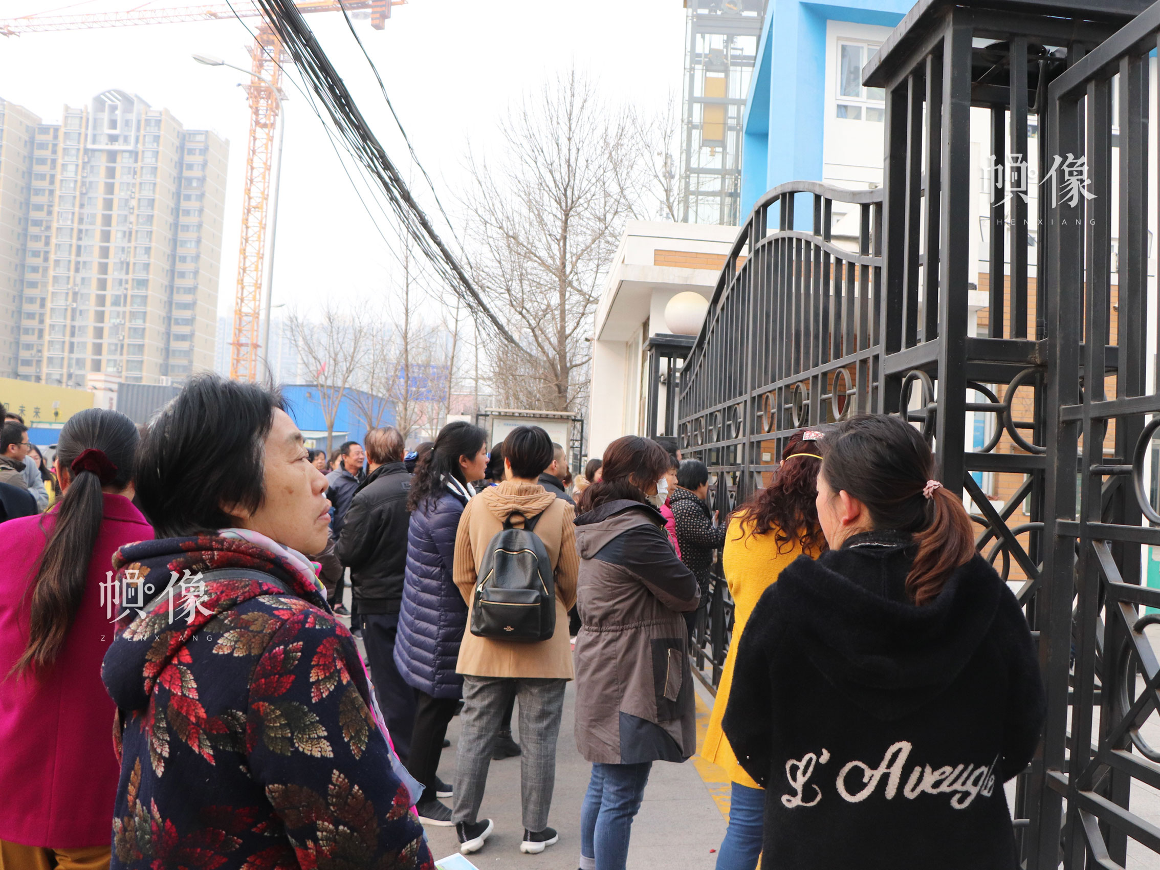 北京市丰台区某小学校门口,正值放学时间,家长们在学校外面等待接孩子