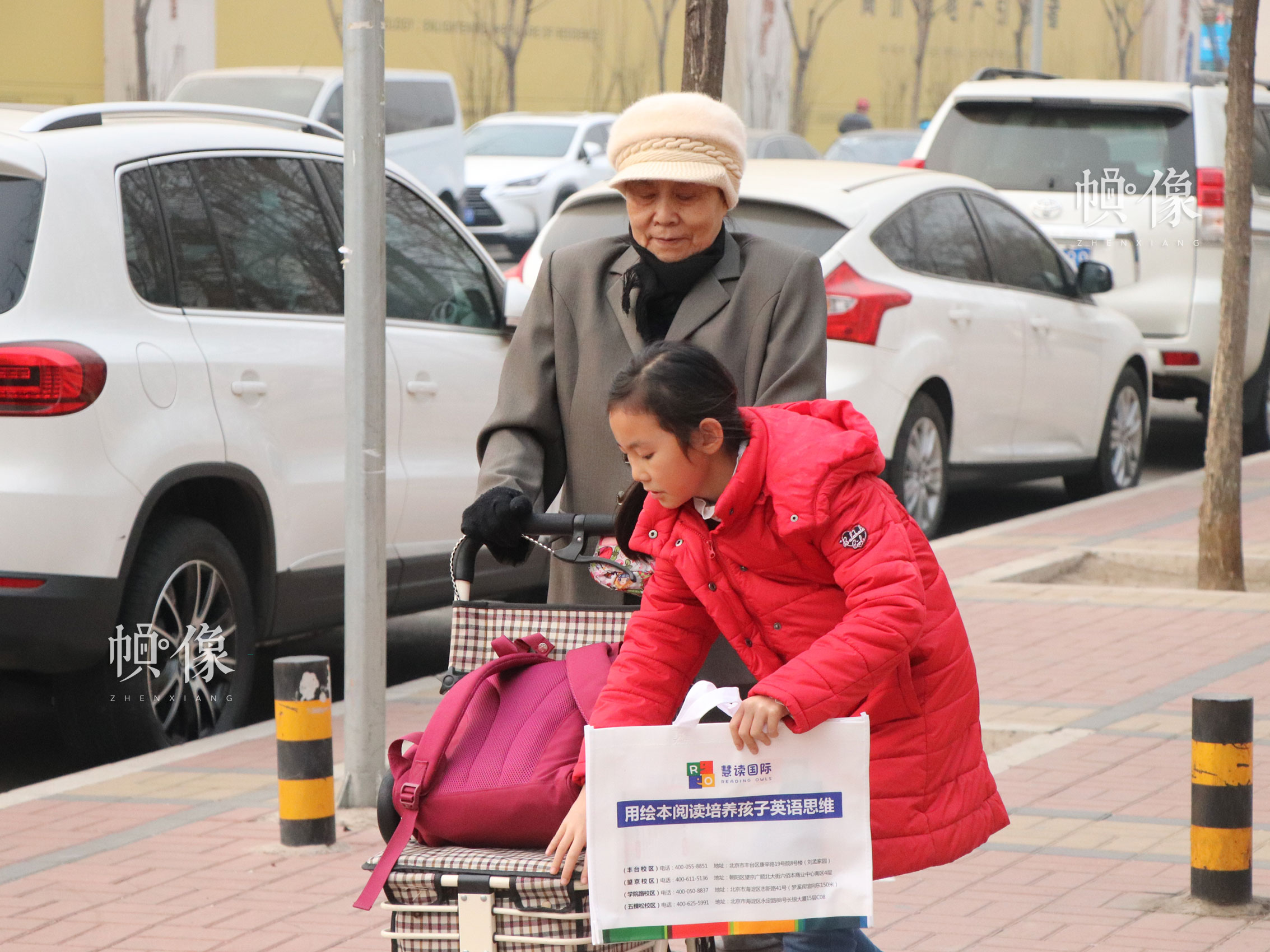 北京市豐台區某小學附近，一位老人接學生放學，用手推車推著孩子的書包，讓孩子減輕身上的“重量”。中國網實習記者 韓依 攝