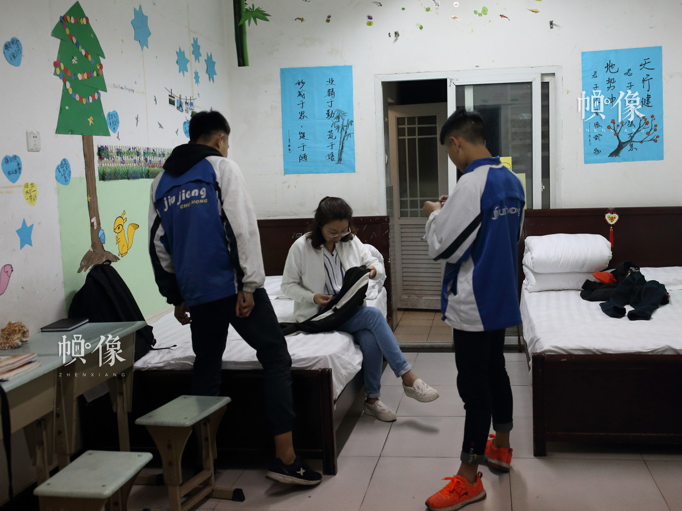 2018年4月，成都雙流安康家園，孩子們的衣服破了，“安康媽媽”王晨在為孩子們縫補。中國網記者 陳維松 攝