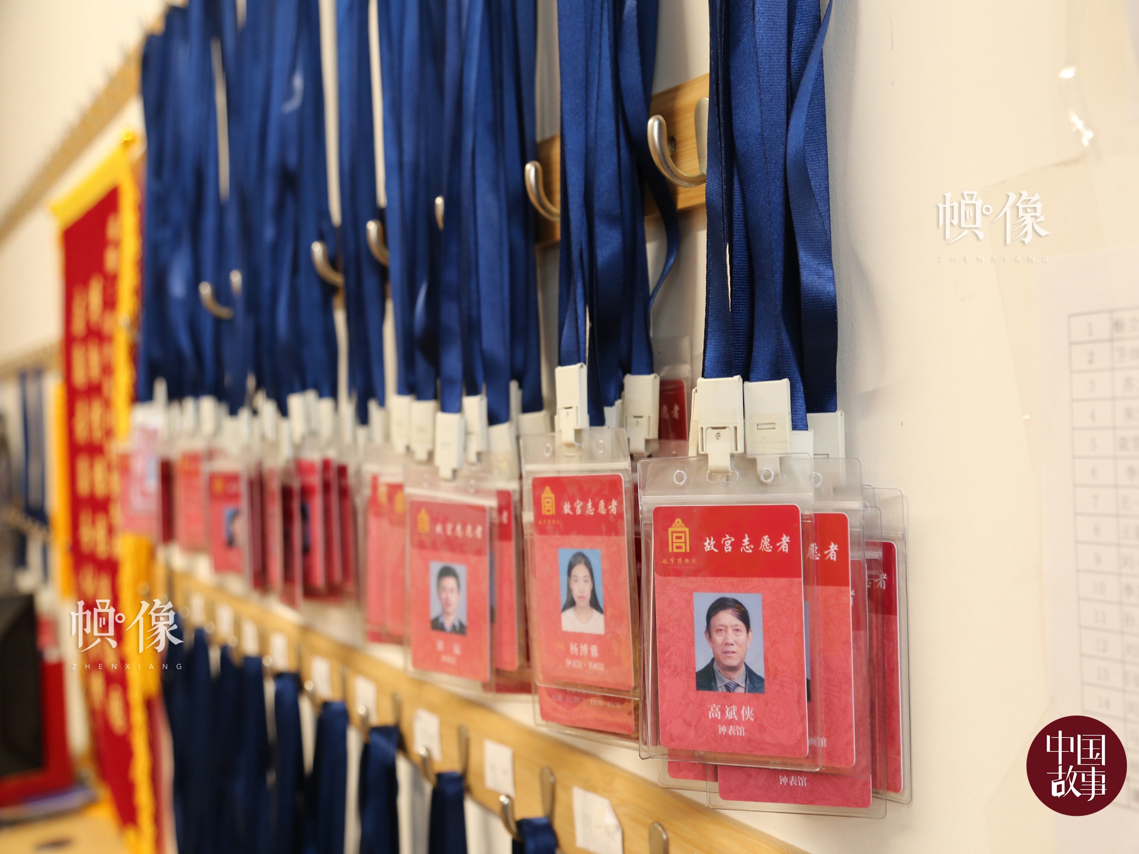 志愿者工作站内，墙上整齐地挂着一排排故宫志愿者工作证。中国网实习记者 赵丹 摄