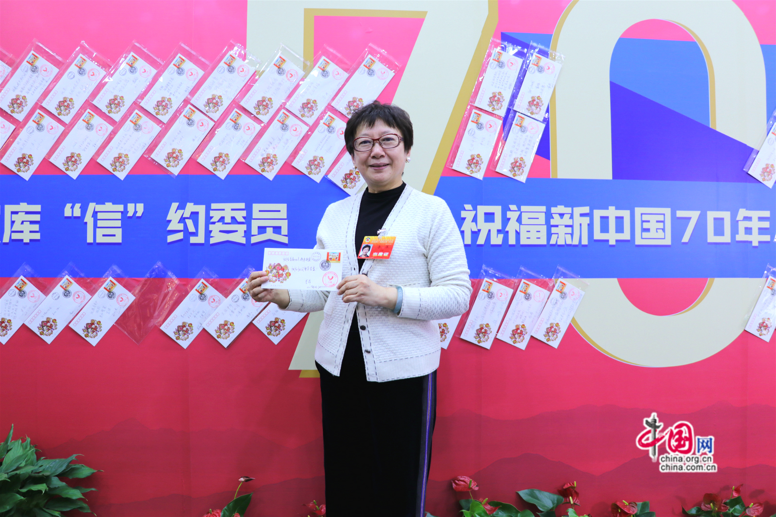 北京市政协委员李萍展示为祖国70年书写的祝福语。中国网记者胡俊摄