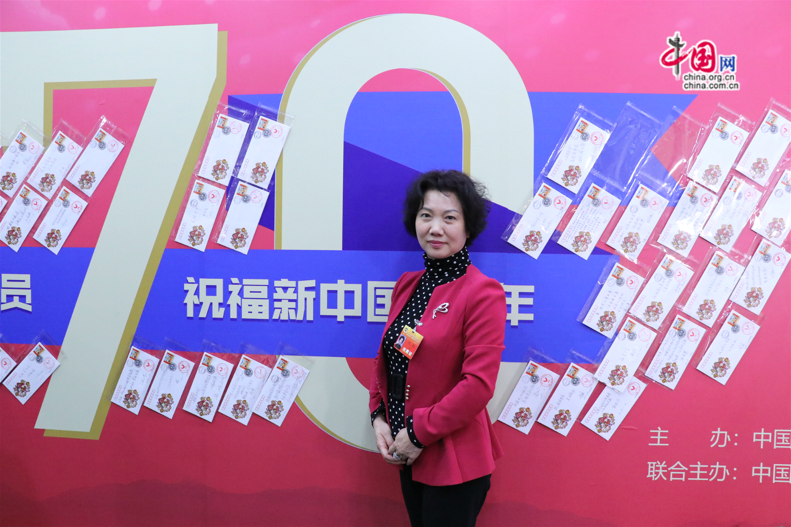 北京市政协委员何玲在70年主题墙前留影。中国网记者胡俊摄