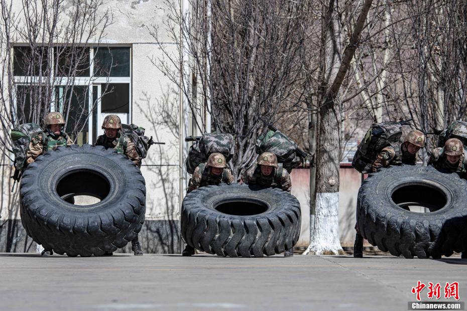 图为官兵在负重条件下进行翻轮胎训练. 王述东 摄