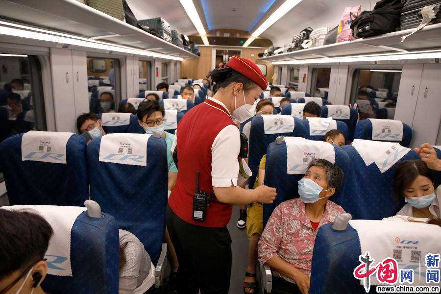 列车长梁建正在服务旅客.中国网记者 卢小凡/摄