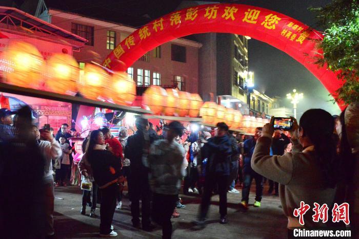 图为刻纸龙灯巡游吸引了许多民众前来观赏。　张斌 摄