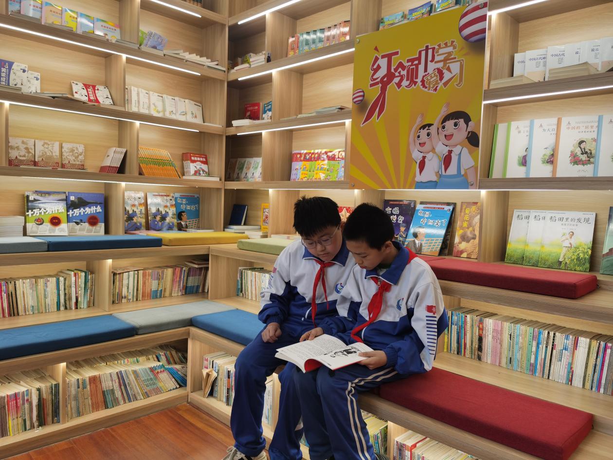 两个孩子（左为张弘宇，右为高宏军）相约来书屋看书。（王莉莉 摄）