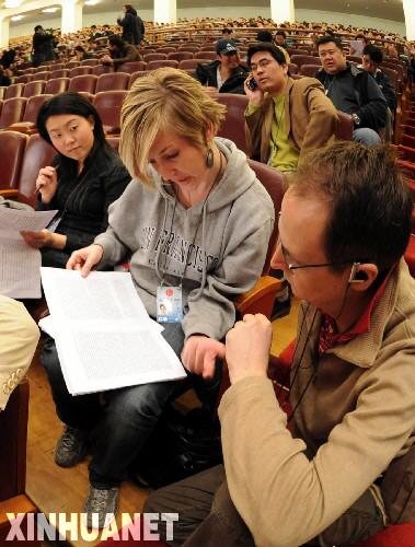 第11期全国人民代表大会第1回会議が3月5日、北京人民大会堂で開幕した。写真は、会場で大会関連資料を見る2人の外国人記者。