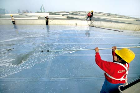 写真：「鳥の巣」の屋上に水をかけて掃除している作業員