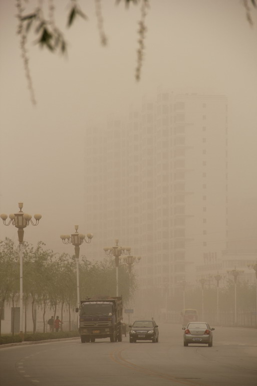 4月29日上午，车辆在沙尘笼罩的甘肃省永靖县刘家峡镇街头行驶。