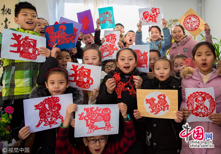 Школьники под руководством учителя умело вырезали из бумаги собак китайского гороскопа для встречи праздника Весны, испытывая очарование культуры китайского гороскопа и выражая прекрасные надежды на новый год.