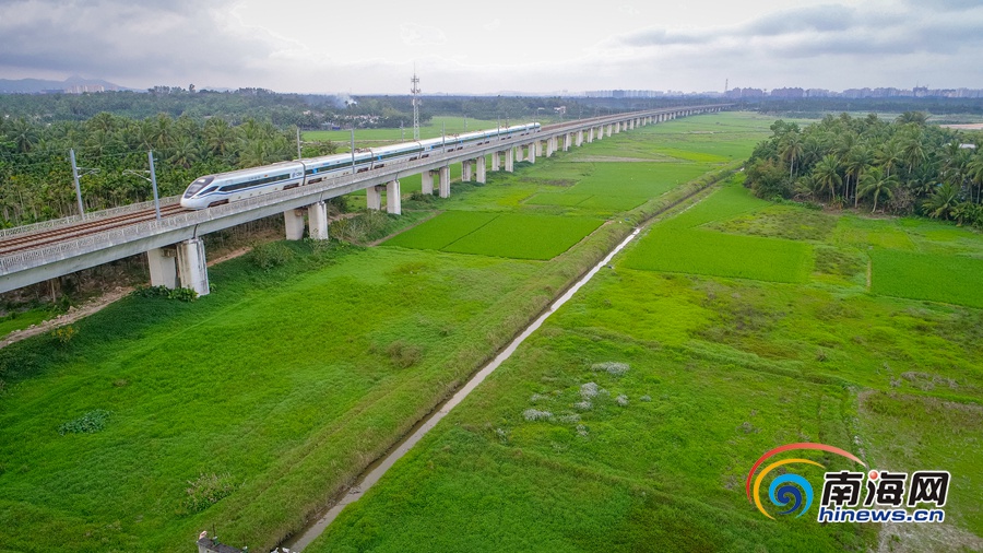 Поселок Боао в городе Цюнхай: высокоскоростный железнодорожный поезд быстро пробегает мимо красивейших полевых пейзажей