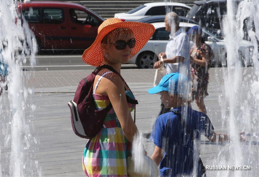 Киевляне спасаются от жары возле фонтанов 