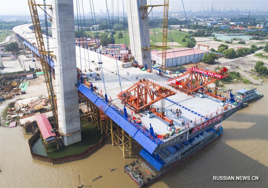 На строительстве большого моста "Циншань" через реку Янцзы в городе Ухань /провинция Хубэй, Центральный Китай/ сегодня завершился монтаж первой стальной коробчатой балки основного пролета. Это значит, что строительные работы вступили в решающую стадию.