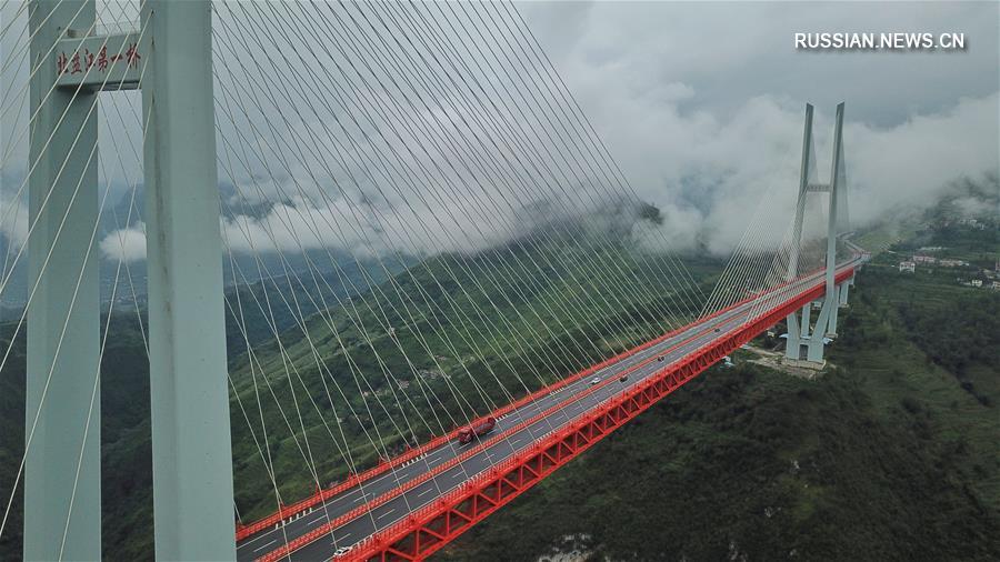Облака и туман окутали сегодня большой мост через реку Бэйпаньцзян в провинции Гуйчжоу /Юго-Западный Китай/. 