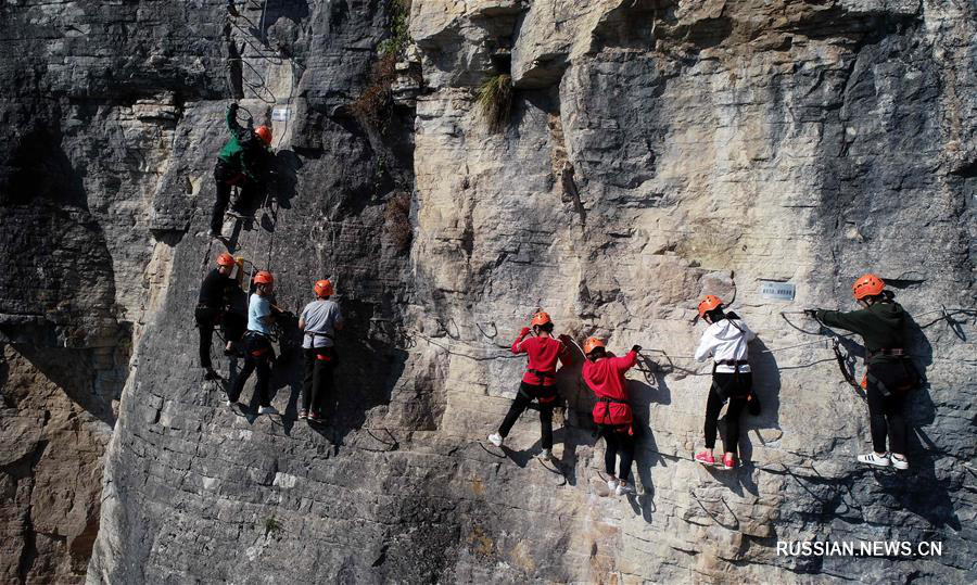 Туристы забираются на скалы в уезде Цзяньши провинции Хубэй