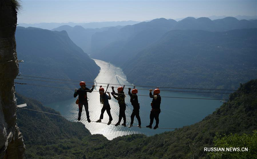 Туристы забираются на скалы в уезде Цзяньши провинции Хубэй